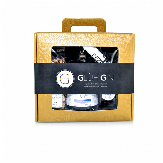 Glüh Gin Geschenkset von Genial Genießen im edlen goldenen Geschenkkoffer mit 500 ml Gin, Glühweingewürz, Hibiskusblüten und Rezeptkarte für winterlichen Genuss.